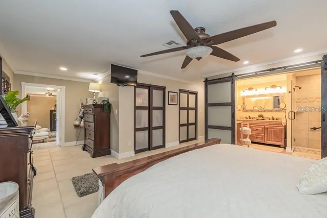 a bedroom with a bed dresser and a large window