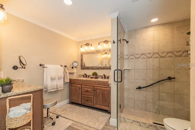 a bathroom with a sink a toilet a mirror and shower