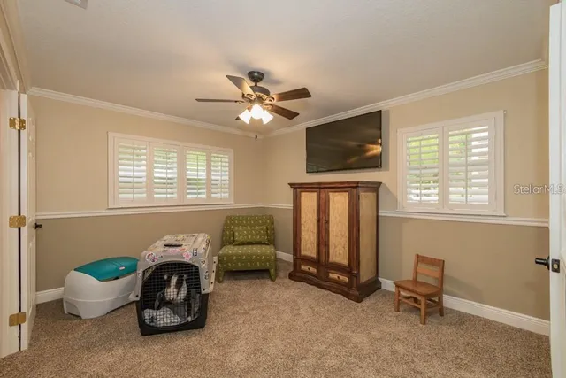 a living room with furniture a flat screen tv and a window
