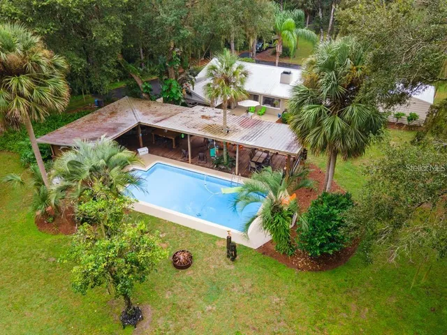 an aerial view of a house with swimming pool garden and patio