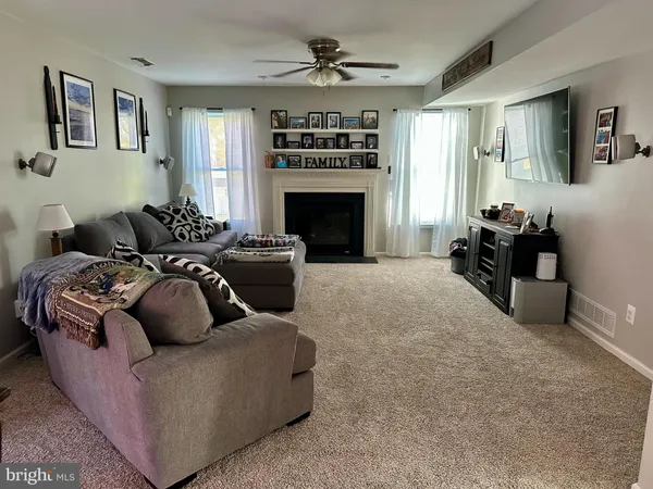 a living room with furniture a fireplace and a chandelier