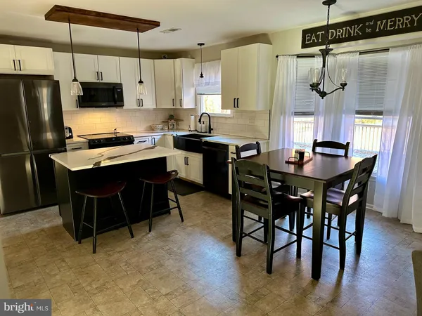 a kitchen with stainless steel appliances granite countertop a table chairs stove a refrigerator and a sink