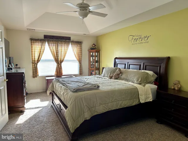 a bedroom with a bed and a large window