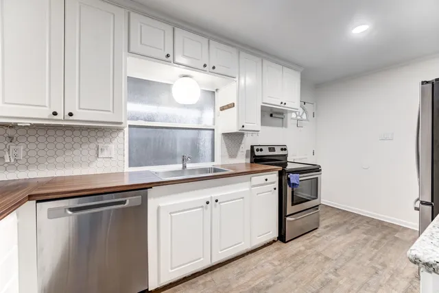 a kitchen with white cabinets and appliances