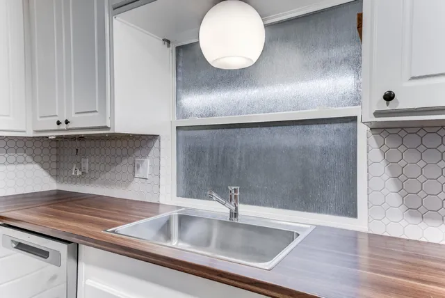 a kitchen with granite countertop a sink and a stove