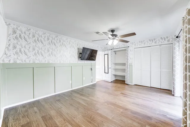 a view of a kitchen with wooden floor and a ceiling fan