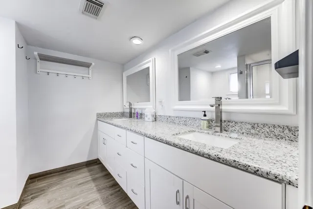 a bathroom with a granite countertop sink and a mirror