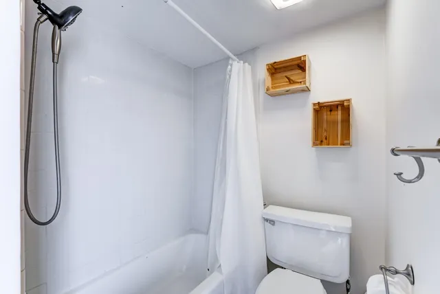 a bathroom with a toilet and a shower
