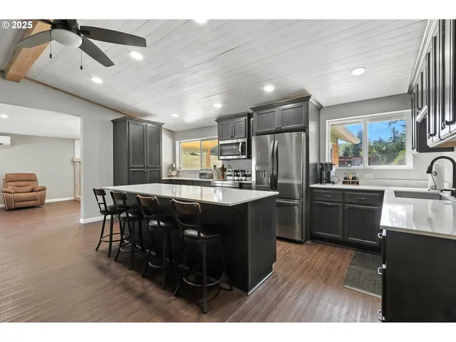 a kitchen with stainless steel appliances kitchen island granite countertop a sink and cabinets