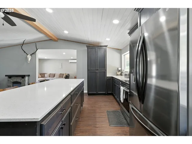 a kitchen with kitchen island a counter top space a sink stainless steel appliances and cabinets