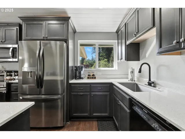 a kitchen with stainless steel appliances a sink and a refrigerator