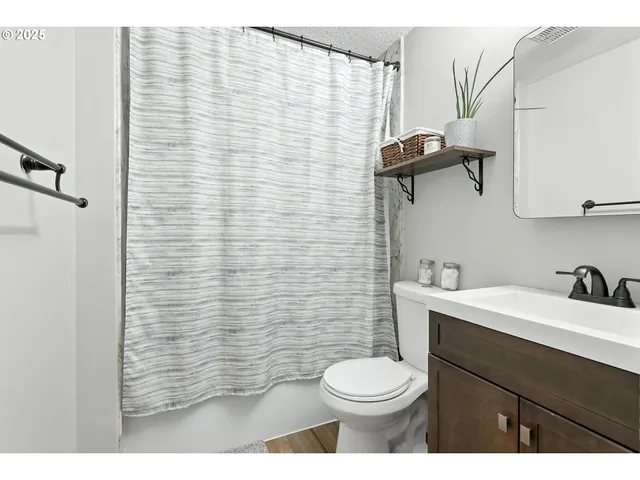 a bathroom with a sink a toilet and shower curtain