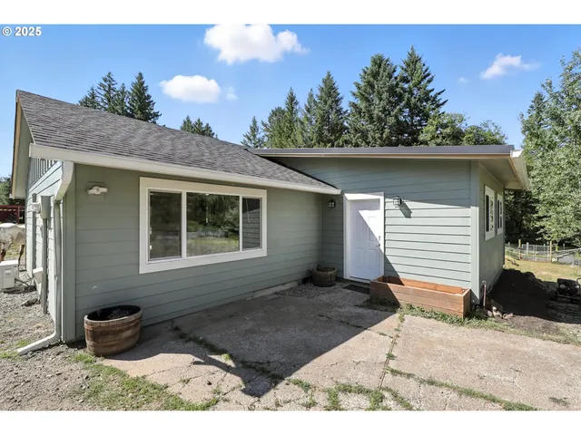 a backyard of a house with table and chairs