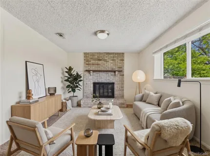 a living room with furniture a fireplace and a large window