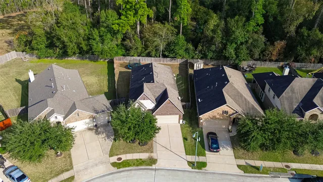 an aerial view of a house with outdoor space and trees all around