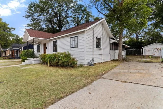 a view of a yard in front of a house with large tree