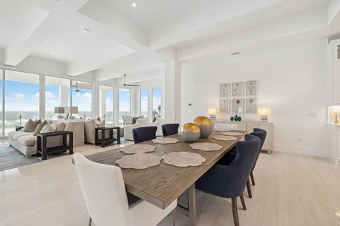 a living room with furniture a large window and a chandelier