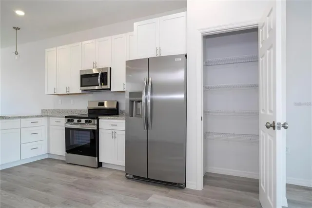 a kitchen with stainless steel appliances cabinets a refrigerator and a stove