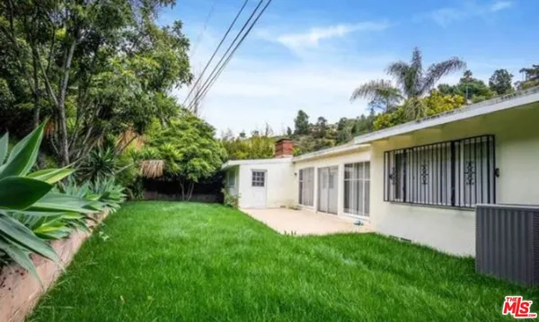 a view of a house with a yard and potted plants