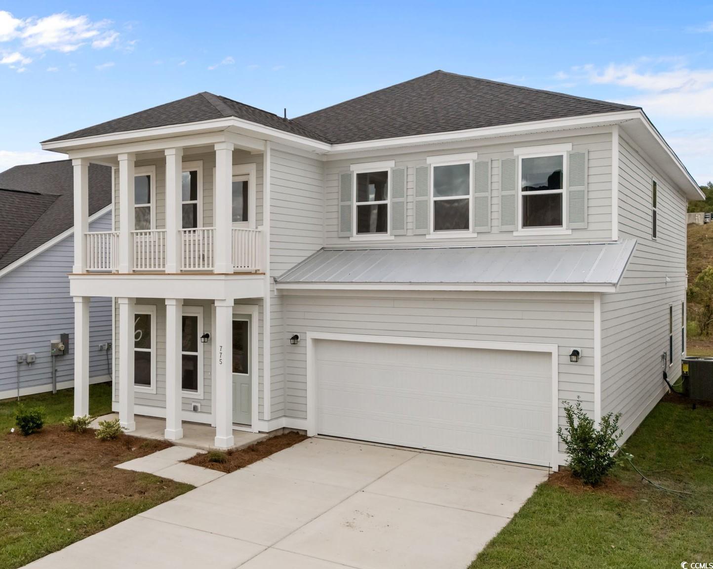 View of front of home featuring covered porch, a shingled roof, concrete driveway, and a garage