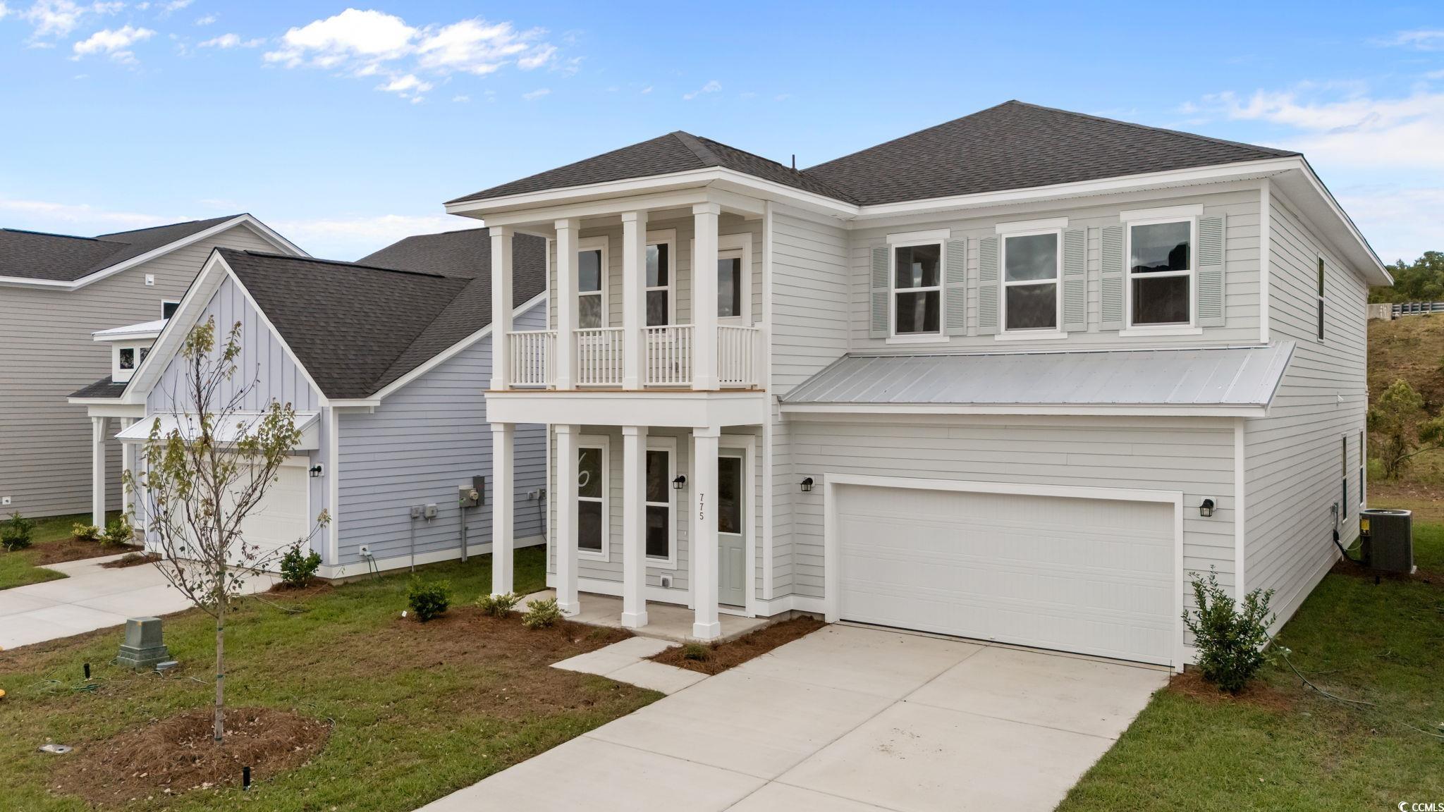 775 Ebb Tide Road Little River, SC 29566 - Photo 2 of 39 View of front facade with roof with shingles, concrete driveway, a balcony, a front yard, and an attached garage