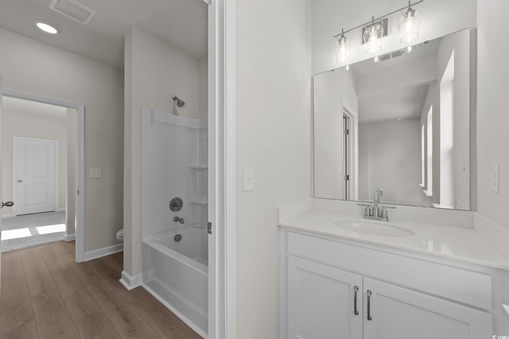 775 Ebb Tide Road Little River, SC 29566 - Photo 22 of 39 Bathroom with washtub / shower combination, vanity, light wood finished floors, and recessed lighting