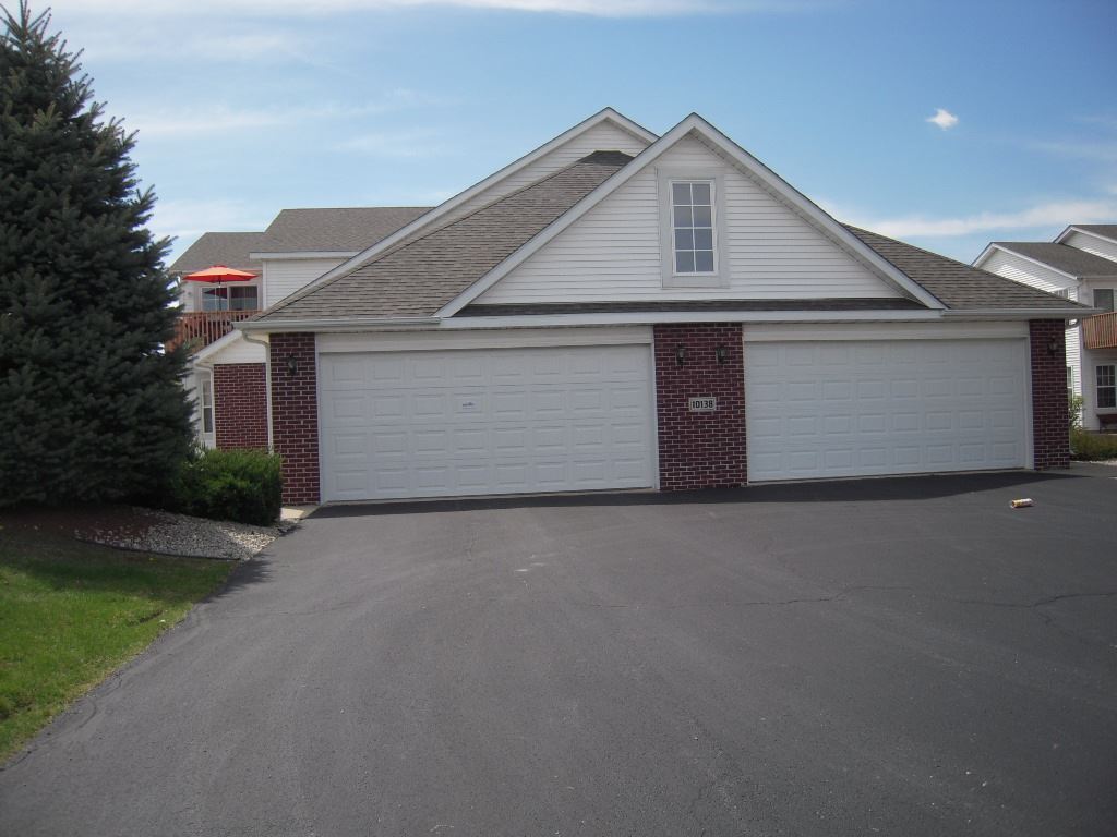 10138 Monarch Road, Unit 2 Roscoe, IL 61073 - Photo 1 of 16 a front view of a house with a yard and garage