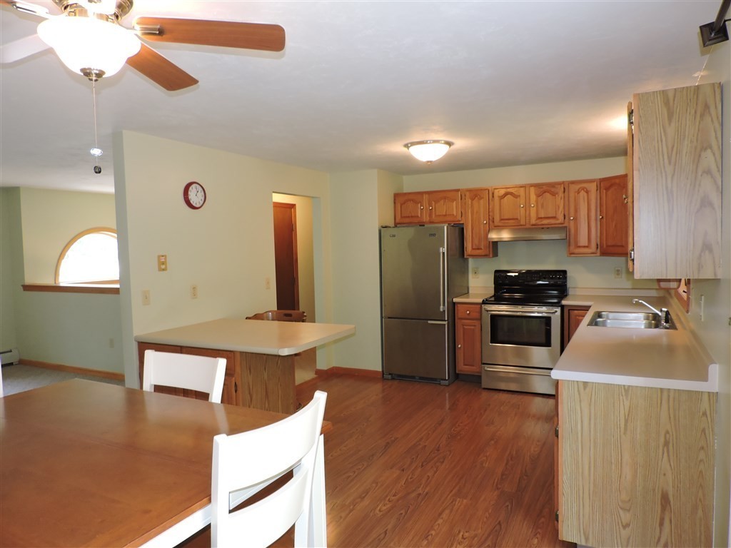 15 Lower Gore Road Webster, MA 01570 - Photo 6 of 30 a kitchen with stainless steel appliances a stove a refrigerator a sink a oven with wooden floor and cabinets