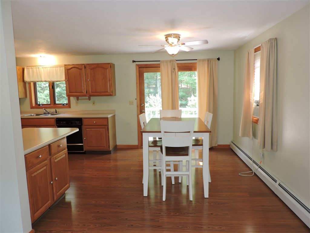 15 Lower Gore Road Webster, MA 01570 - Photo 8 of 30 a kitchen with stainless steel appliances granite countertop wooden floor cabinets and dining table
