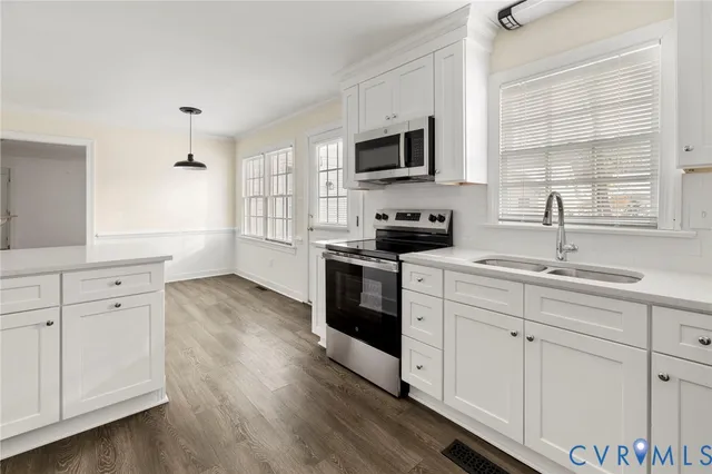a kitchen with white cabinets stainless steel appliances and sink