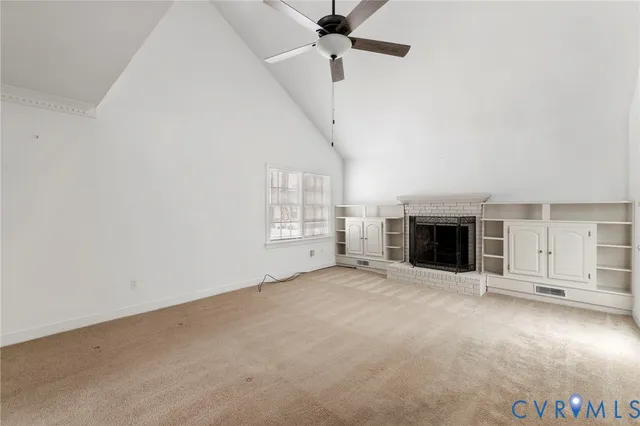 an empty room with windows and fireplace