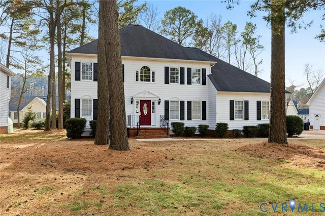 a view of a white house with a large tree in front of it