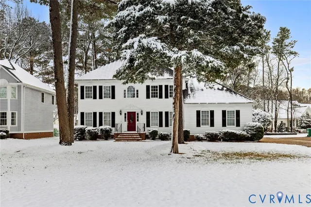 a front view of a house with a yard covered in snow