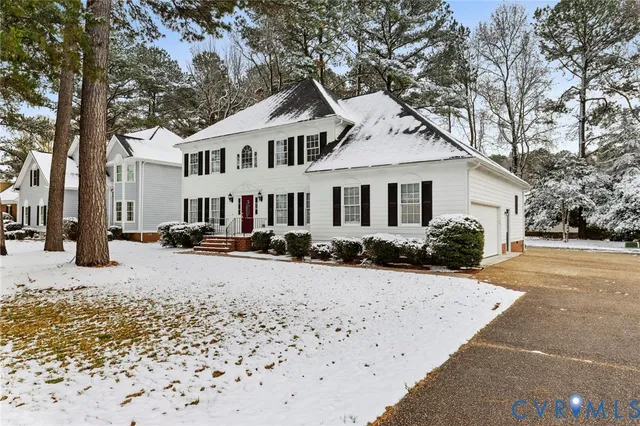 a view of a white house with a large tree in front of it