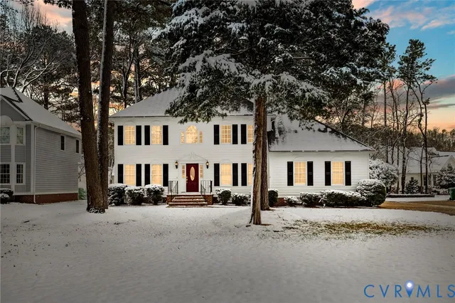 a front view of a house with a yard covered in snow