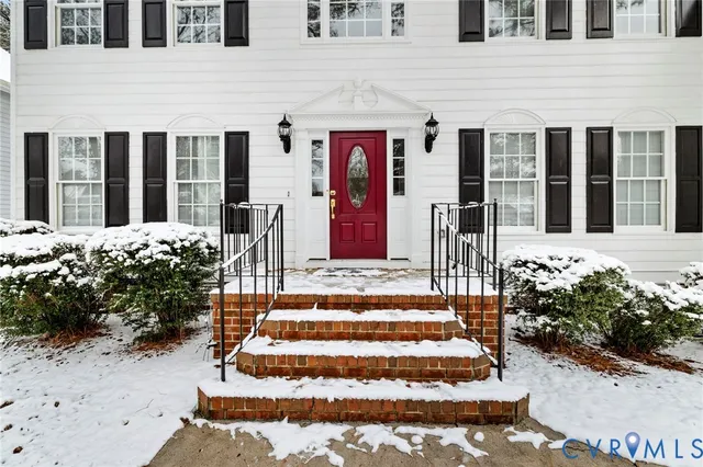 a kitchen with stainless steel appliances a sink dishwasher a stove top oven a refrigerator with white cabinets and wooden floor