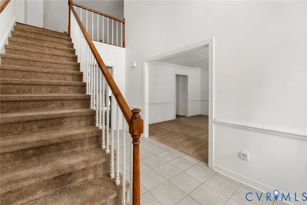 a kitchen with granite countertop a stove a sink dishwasher a refrigerator and white cabinets with wooden floor