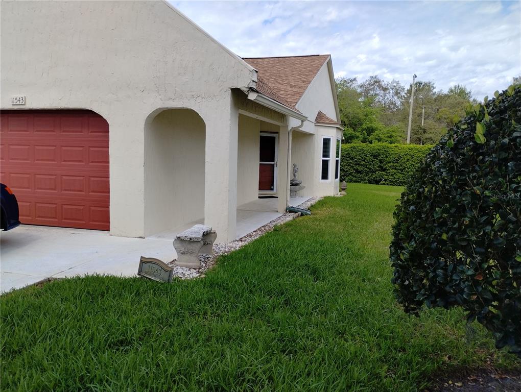 11543 Orleans Lane, Unit B Port Richey, FL 34668 - Photo 2 of 11 a front view of a house with garden