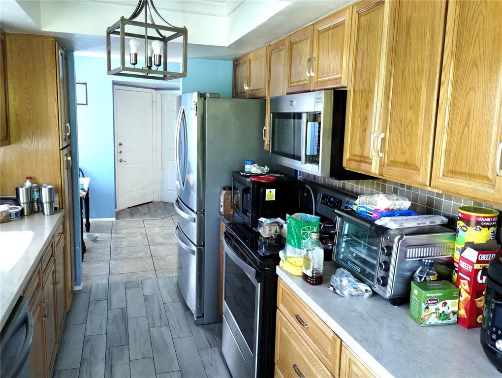 11543 Orleans Lane, Unit B Port Richey, FL 34668 - Photo 3 of 11 a kitchen with stainless steel appliances granite countertop a refrigerator and a stove