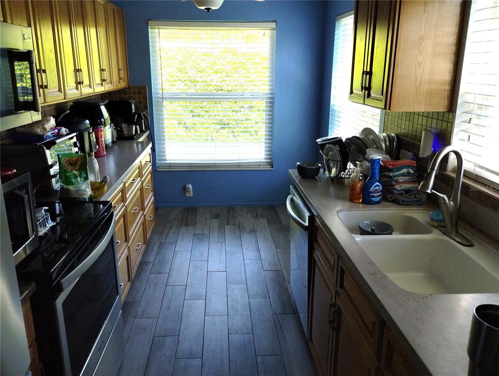 11543 Orleans Lane, Unit B Port Richey, FL 34668 - Photo 4 of 11 a kitchen with a sink a window and wooden floor