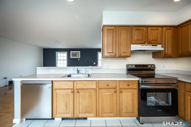a kitchen with granite countertop a stove sink and cabinets
