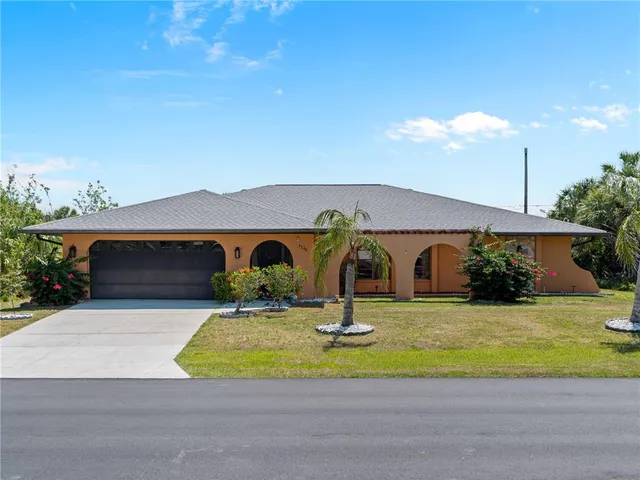 a view of a house with a yard and potted plants