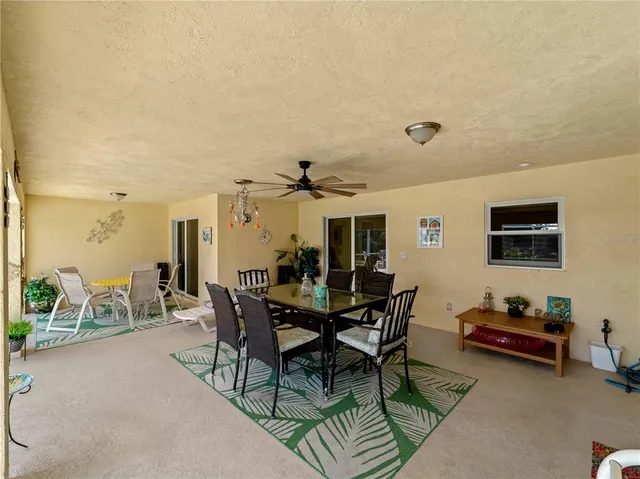 an aerial view of a house with yard and trees in the background