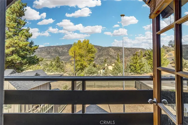 a view of a house with a small yard and wooden fence