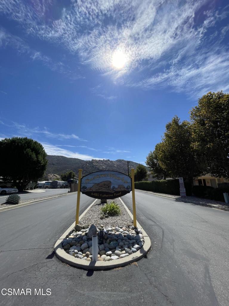 6480 Katherine Road, Unit 6 Simi Valley, CA 93063 - Photo 29 of 34 a backyard of a house with table and chairs under an umbrella
