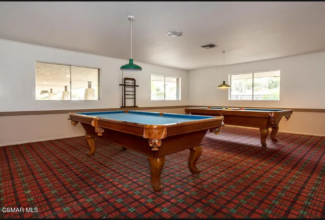 a room with pool table and windows