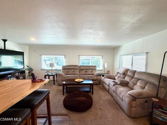 a living room with furniture a large window and a flat screen tv