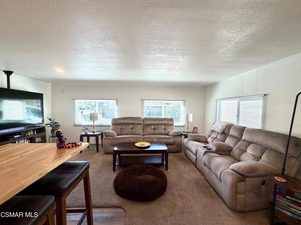 6480 Katherine Road, Unit 6 Simi Valley, CA 93063 - Photo 6 of 34 a living room with furniture a large window and a flat screen tv