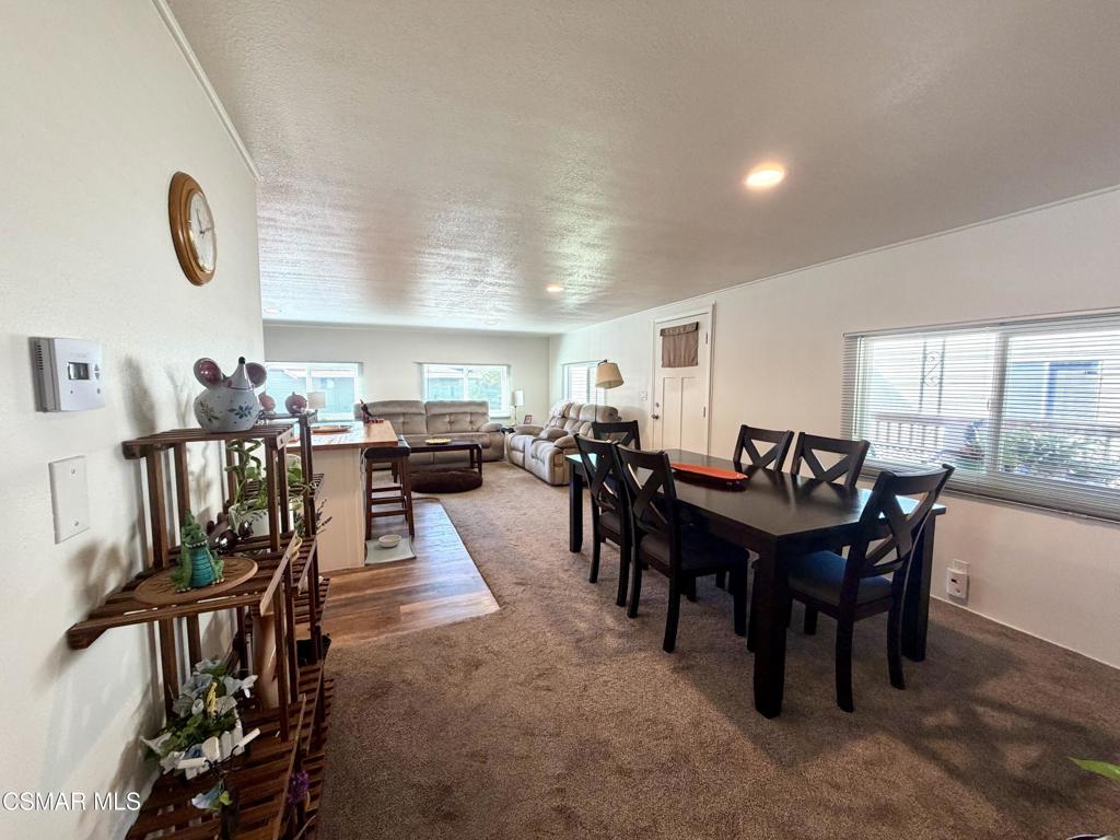 6480 Katherine Road, Unit 6 Simi Valley, CA 93063 - Photo 7 of 34 a view of a dining room and livingroom with furniture a rug a painting and a chandelier