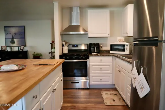 a kitchen with white cabinets and appliances